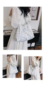 Détail du sac à bandoulière en toile florale avec fermeture à cordon et motifs violets