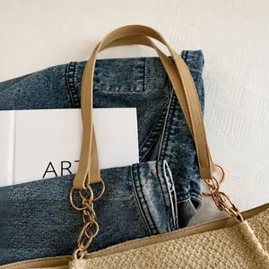 Detalle del bolso tote tejido con asa de cuero sintético y anillos dorados