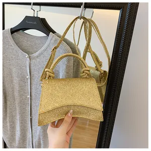 Gros plan du sac à main doré à paillettes avec poignée nouée et bandoulière fine