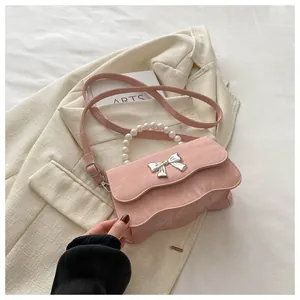 Detailed view of pink wavy leather handbag with pearl handle and silver butterfly clasp