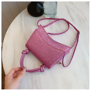 Gros plan d'un sac à main rose scintillant avec poignée nouée sur marbre