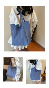 Detail view of the hazy blue oxford cloth tote bag showing outer pocket and large capacity