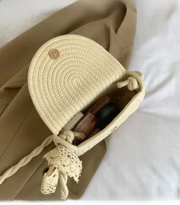 Detail view of the woven half-moon bag with gold magnetic clasp and lace bow detail