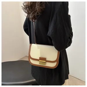 Detail of vintage saddle bag with canvas-leather patchwork and gold metal clasp