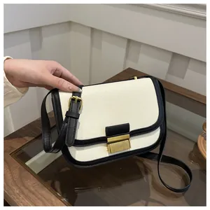Detailed view of canvas shoulder bag with black leather trim and vintage gold clasp