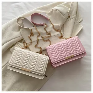 Detailed close-up of V-shaped quilting and gold metal lock on small chain crossbody bags