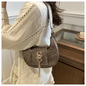 Détail du sac demi-lune vintage gris-brun avec boucle S dorée et glands en métal