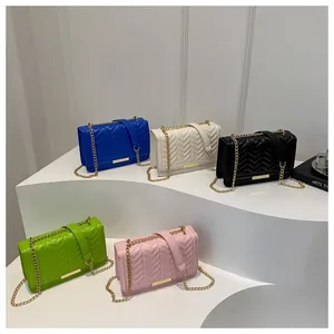 Detail of five quilted crossbody bags with gold chains in blue, beige, black, green, and pink