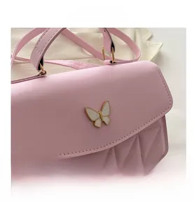 Detail of pink leather handbag with white enamel butterfly buckle and quilted texture