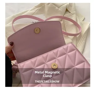 Detail of pink quilted handbag showing golden magnetic buckle and fine craftsmanship
