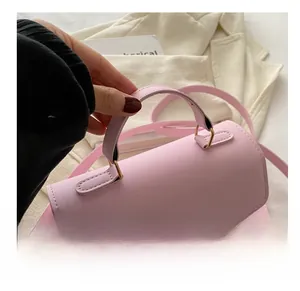 Detail of pink PU leather handbag showing comfortable top handle and gold butterfly buckle