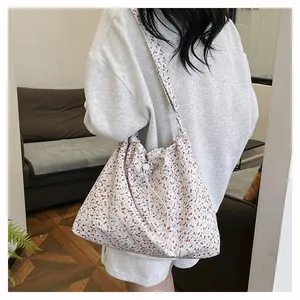 Détail du sac à bandoulière floral avec cordon de serrage dans un décor intérieur
