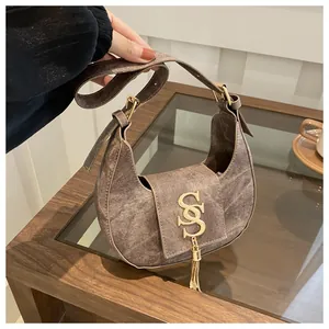 Vue détaillée du sac demi-lune marron vintage avec logo SS doré et gland en métal