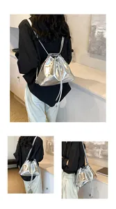 Detail of silver metallic bucket bag with drawstring closure and versatile straps