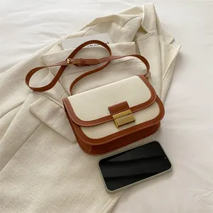 Chic two-tone canvas and leather saddle bag with vintage metal lock and shoulder strap