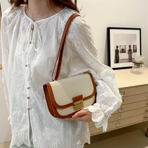 Chic beige canvas and brown leather saddle bag for women with a vintage metal lock clasp