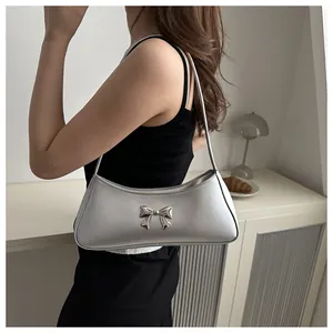 Nœud argenté sur sac à bandoulière métallisé dans un décor intérieur moderne