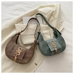 Détails de sacs demi-lune rétro avec logo doré et élégantes pampilles à franges