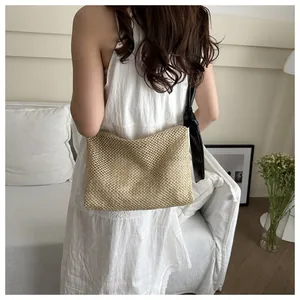French style woven straw tote bag with black leather strap shown on white dress model