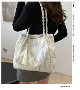 Dettaglio della borsa tote trapuntata bianca con ricami colorati e manici in corda