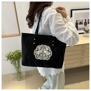 Détail d'un sac cabas noir avec broderie florale chinoise et tissu au fini texturé rétro