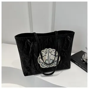 Détail d'un cabas noir plissé avec broderie traditionnelle chinoise et texture brillante