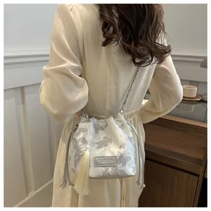 Detail der silbernen Beuteltasche mit Schmetterlingsdruck, Perlenquaste und Kette
