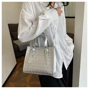 Detail of silver woven crossbody bag with Fashion Bags logo and metallic texture