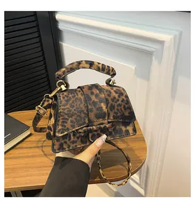 Detail of leopard print mini square bag featuring adjustable strap and leather texture