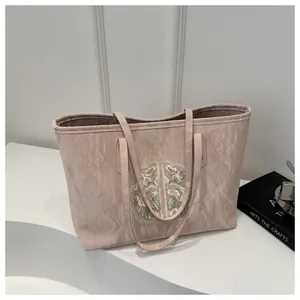 Détail du sac cabas rose avec texture marbrée et broderie ethnique sur toile douce