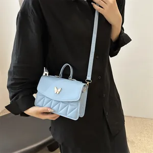 Elegant light blue quilted handbag with gold butterfly clasp and crossbody strap for women