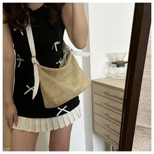 Close-up of woven straw tote bag texture with adjustable white leather shoulder strap