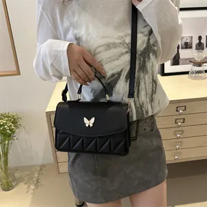 Black leather crossbody bag with butterfly ornament and geometric quilted texture