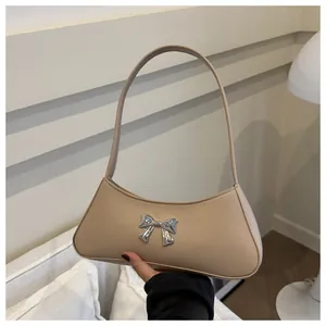 Dettaglio della borsa a spalla kaki con fiocco in metallo argento e similpelle liscia