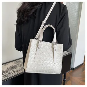 Close-up of white woven texture handbag with FASHION BAGS logo and metal buckle