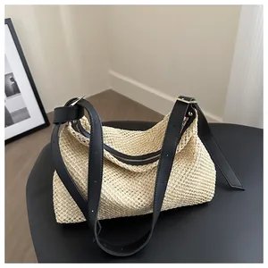 Close-up of the woven texture, black leather strap, and silver buckle on this tote bag