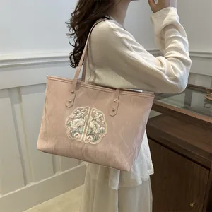 Sac fourre-tout élégant en toile rose pâle avec broderie florale et rivets métalliques