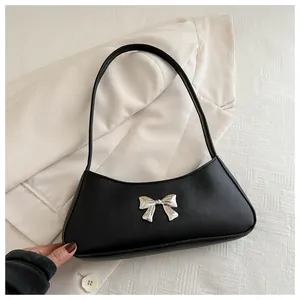Détail du nœud argenté sur un sac hobo croissant en similicuir noir pour femmes