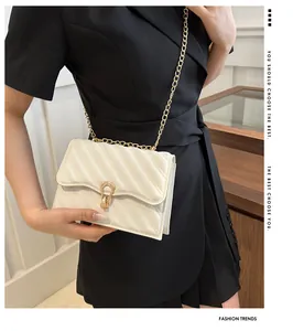 Detail of a beige quilted leather bag with a gold chain strap worn by a model