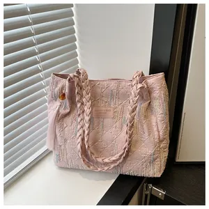 Dettaglio della borsa rosa con motivo logo F in rilievo e manici intrecciati moda