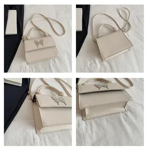 Vista multiángulo de un bolso bandolera beige con un cierre decorativo de mariposa plateada