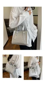 Detailed close-up showing the silver woven texture and metallic finish of this crossbody bag