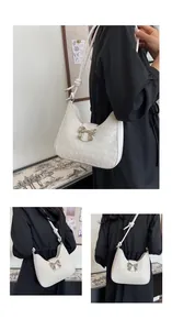 Detail of woven hobo bag showing silver bow buckle and knotted shoulder strap design
