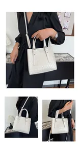 Detail of white woven crossbody bag showing textured PU leather and metallic buckles