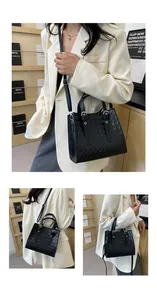 Detail of black woven tote bag with adjustable shoulder strap and metal buckle hardware