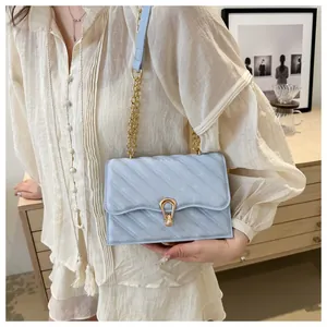 Detail shot of light blue quilted leather bag with iconic golden snake head closure