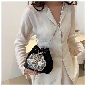 Détail du sac seau en velours noir avec broderie florale et accents de perles