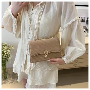 Detailed macro view of khaki quilted suede bag with elegant golden teardrop buckle hardware
