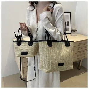 Detalle de bolsos de paja tejida con adornos de cuero negro en dos tamaños