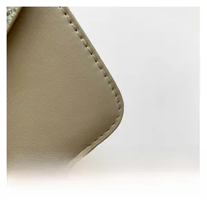 Close-up of premium beige leather texture and meticulous stitching of the shoulder bag